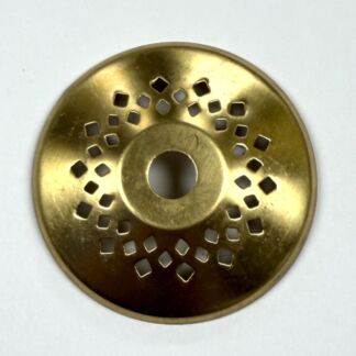 Gold-toned metal drain cover with a circular central hole and a pattern of square perforations radiating outward.