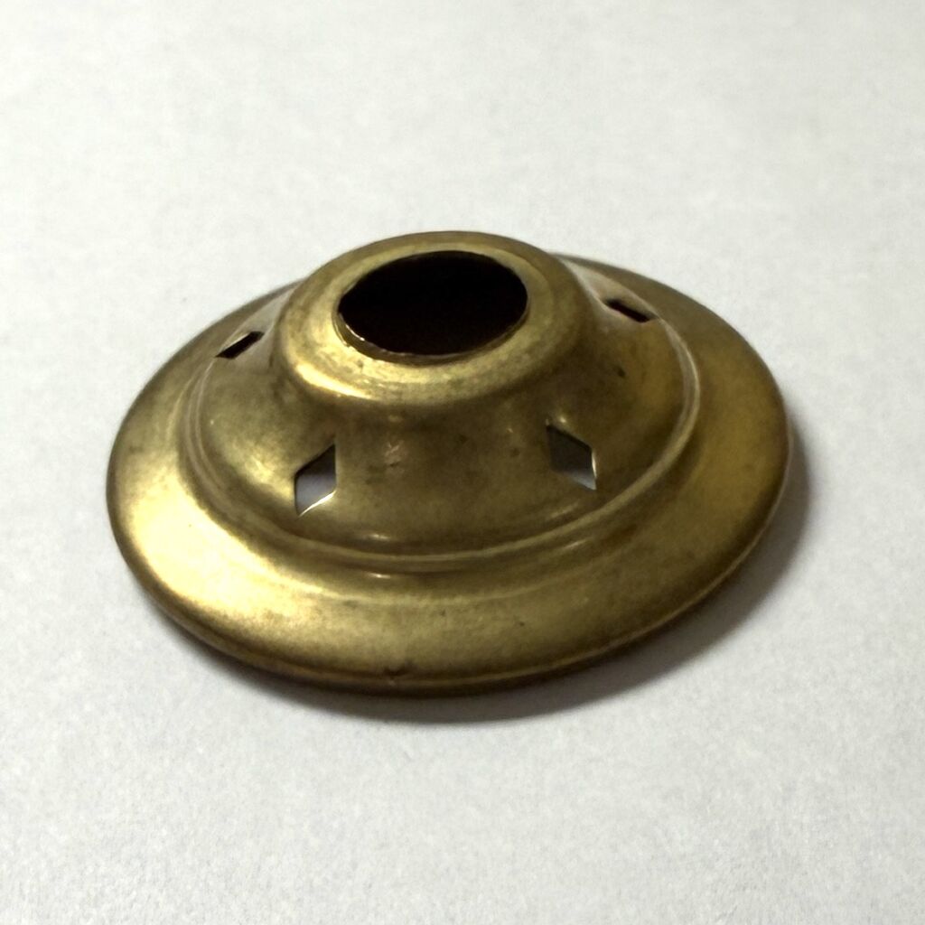 Brass hemispherical ceiling light fixture component with central hollow opening and small square cutouts around it