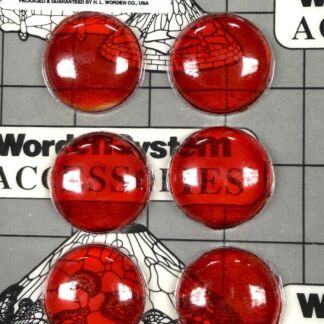 Six shiny red circular glass cabochons arranged on a grid background, with vintage labels saying 'No. 25 - Orange' and 'Jewels Made in Germany.'